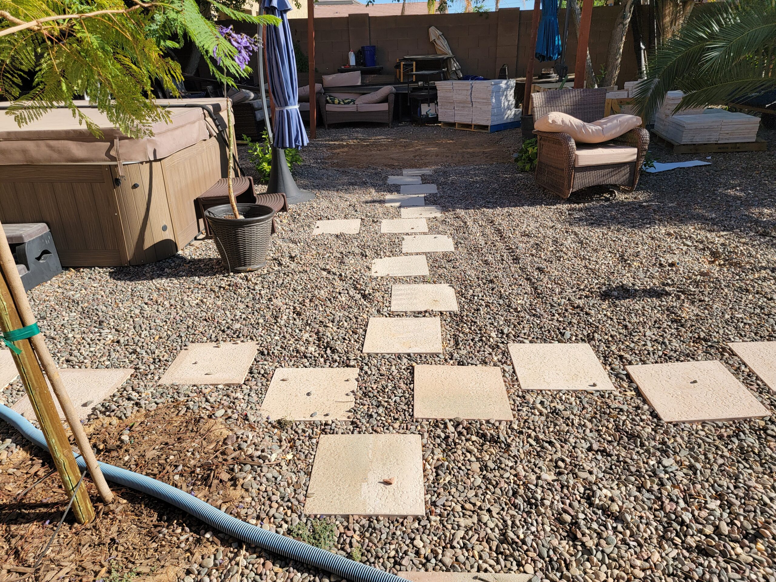Ivory travertine pavers and gravel pathway around a Phoenix pool deck and hot tub.