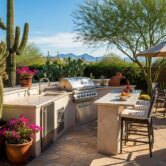 Outdoor kitchen in a Phoenix backyard featuring a grill and natural stone countertops